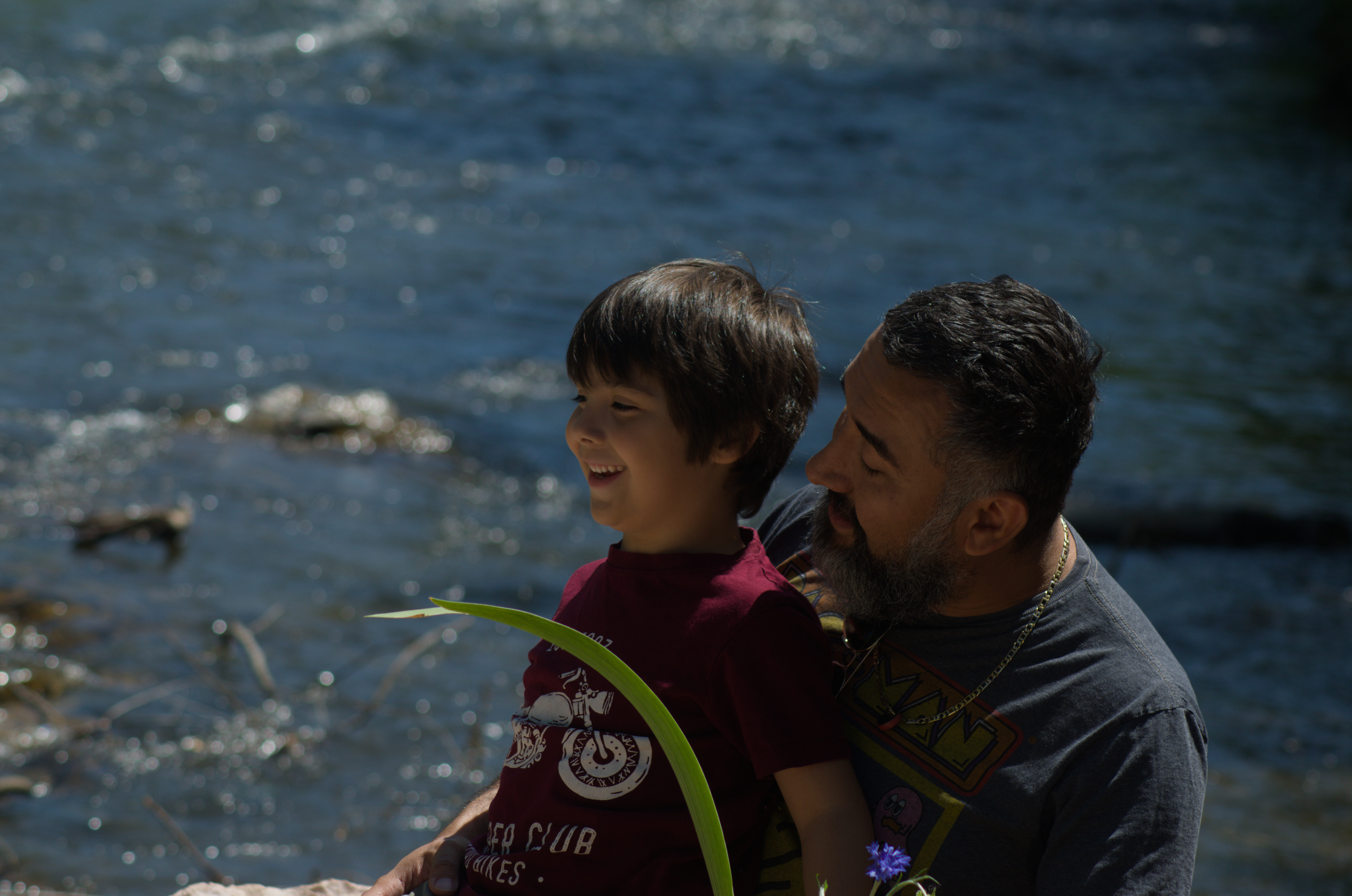 Father and son sharing a joyful moment by the river